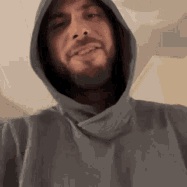 a man with a beard is wearing a hooded sweatshirt