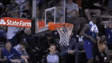 a basketball game is being played in front of a state farm sign