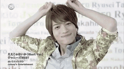 a young man with his hands on his head is smiling .