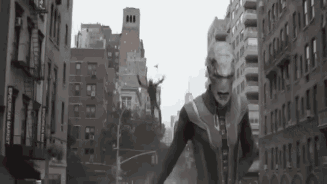 a man in a suit is walking down a city street with buildings in the background