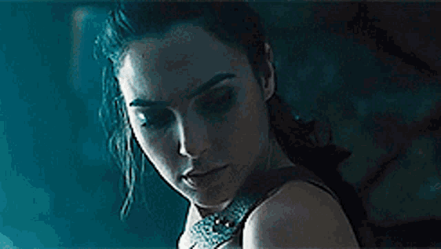 a close up of a woman 's face with a ponytail in a dark room .