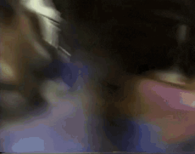 a blurry picture of a person 's face with a purple and blue background