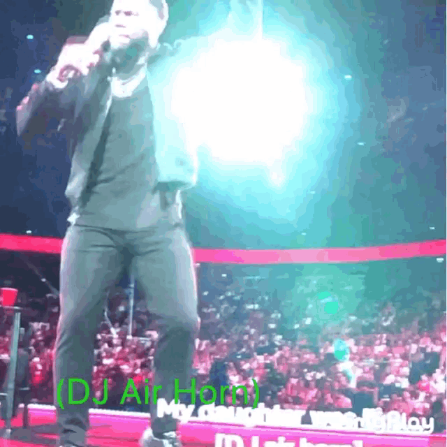 a man singing into a microphone in front of a crowd with the name dj air horn on the bottom right
