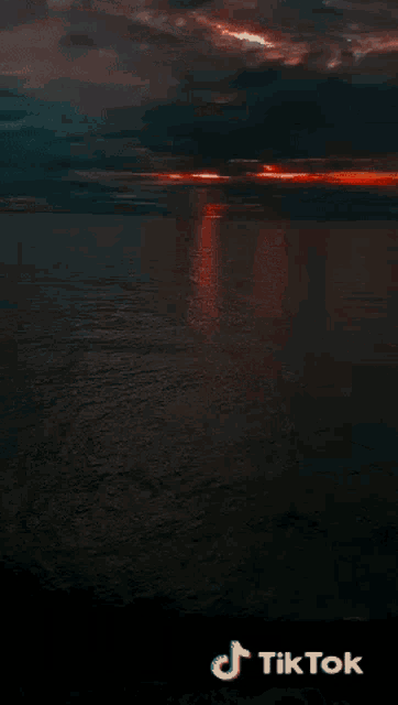 a picture of a sunset over a body of water has tiktok written on it