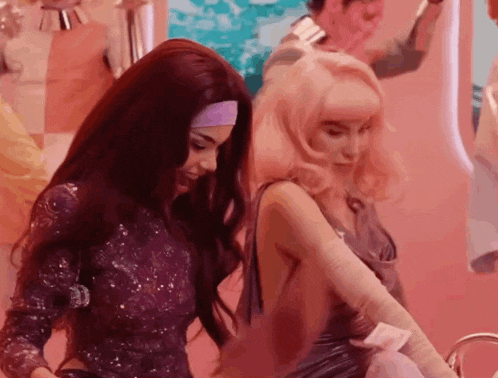 two women are standing next to each other in a room