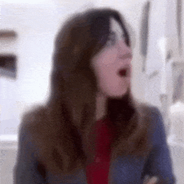 a blurry picture of a woman with her mouth open and her eyes closed .