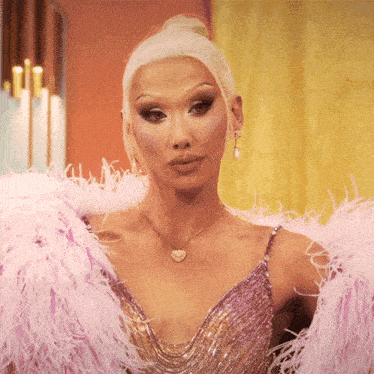 a woman wearing a pink feathered jacket and a necklace with a heart pendant