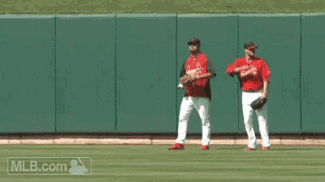 two baseball players on a field with the mlb.com logo
