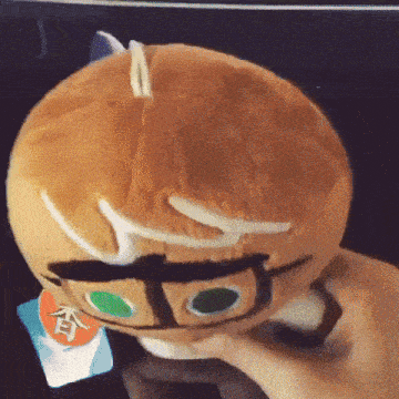 a person is holding a stuffed animal that looks like a cookie monster