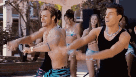 a group of young men and women are dancing together in a pool .