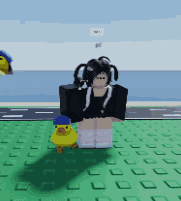 a girl with pigtails is standing next to a yellow duck with a blue hat