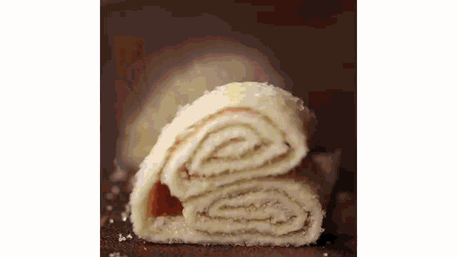 a close up of a slice of bread rolled up on a table .