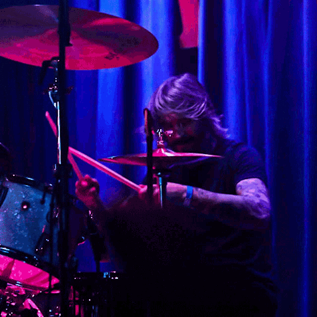 a man playing drums with a cymbal that says sabian