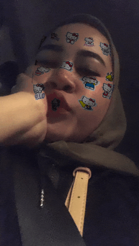 a girl with hello kitty face paint on her face