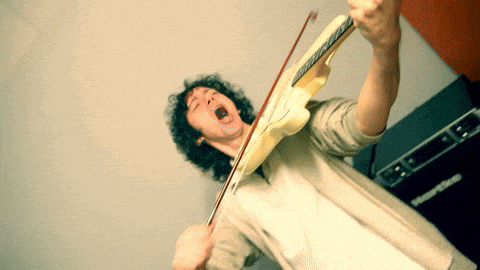 a man playing a violin in front of an orange box