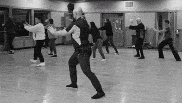 a group of people are practicing martial arts in a room