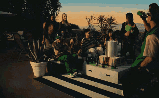 a group of people are gathered around a table with bottles of beer