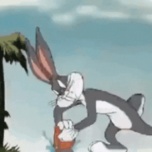 bugs bunny from looney tunes is drinking water from a bucket while standing next to a palm tree .