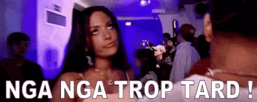 a woman is standing in a crowded room with the words nga nga trop tard written on the bottom