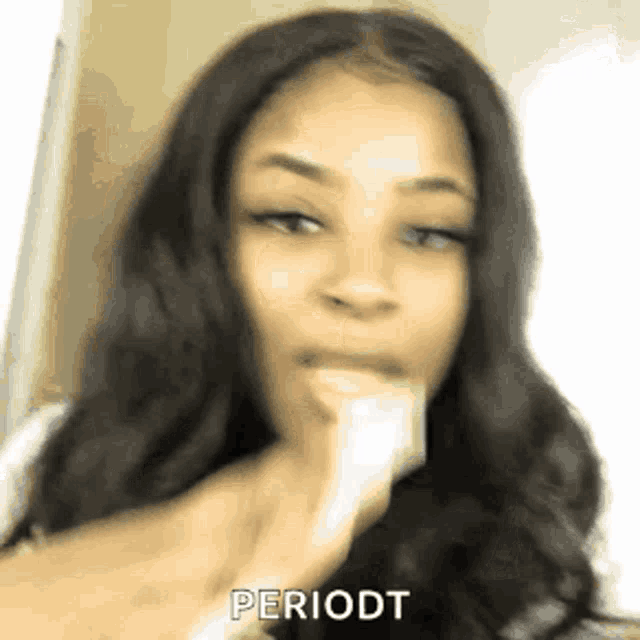 a woman with long black hair is eating a banana and says periodt