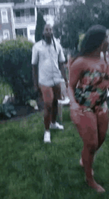a man and woman are dancing in the grass .