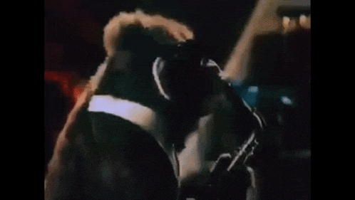 a monkey is wearing sunglasses and a tuxedo and playing a saxophone .
