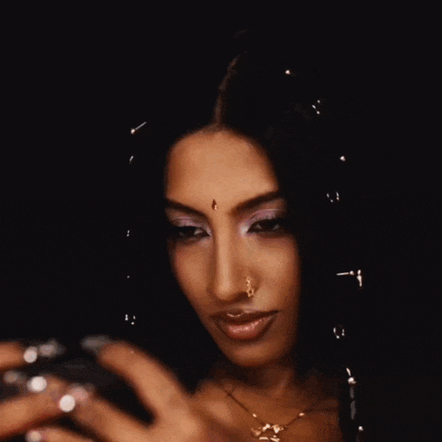a woman with a nose ring is taking a selfie with her phone
