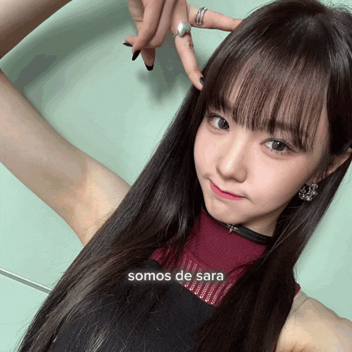 a girl with long hair and the word somos de sara on the bottom right