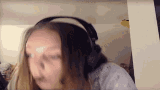 a woman wearing headphones is making a funny face .