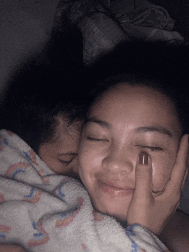 a woman kissing another woman on the forehead