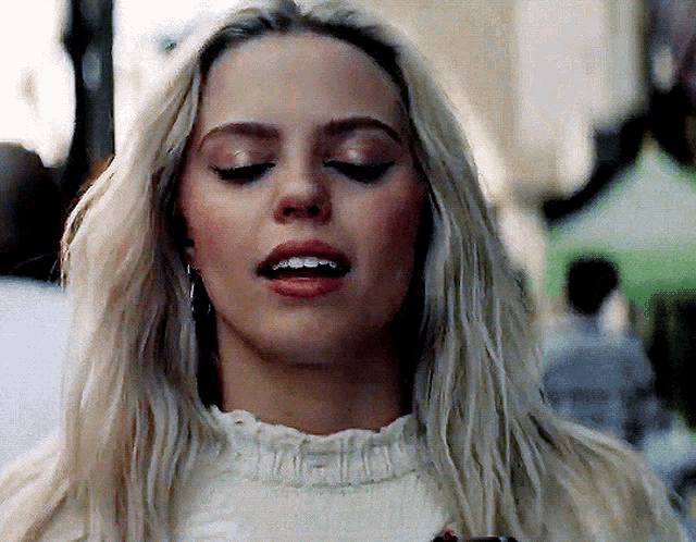 a close up of a blonde woman with her mouth open