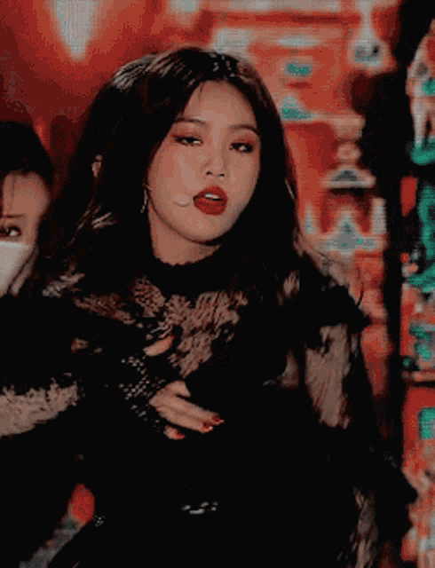 a woman in a black lace top is making a funny face with her eyes closed