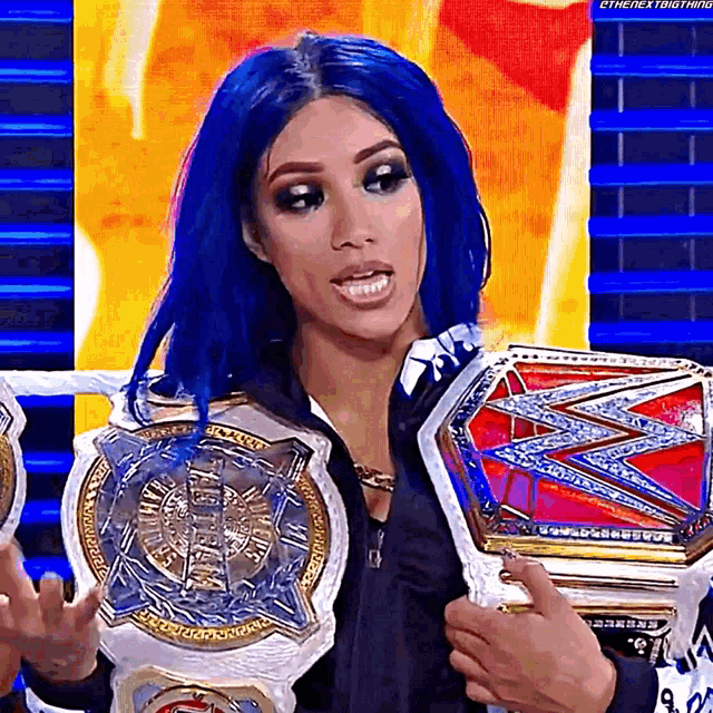 a woman with blue hair is holding a world heavyweight championship belt .