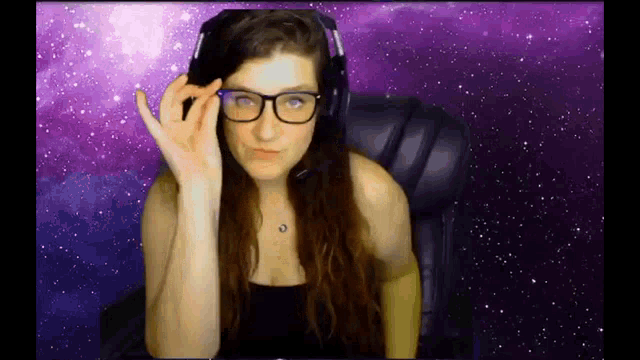 a woman wearing glasses and headphones sitting in a chair