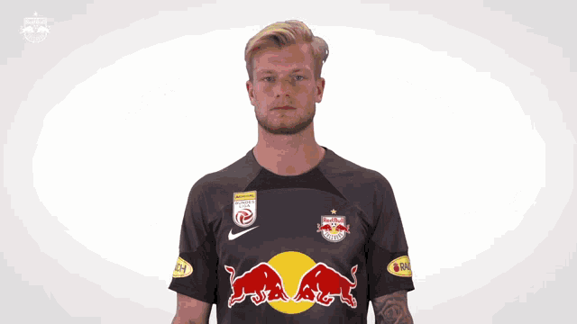 a man wearing a black shirt with red bulls on the front