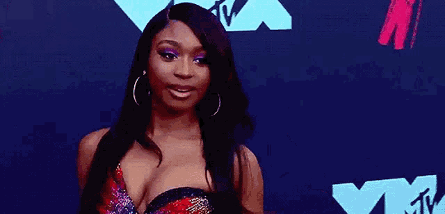 a woman is standing on a red carpet wearing a very revealing dress .
