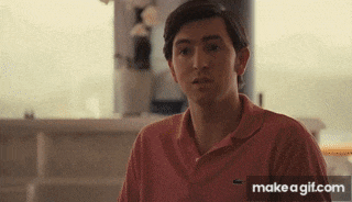 a young man wearing a pink polo shirt is looking at the camera .