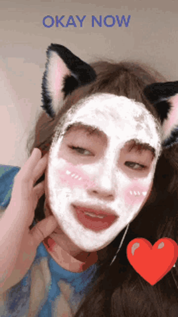 a woman with cat ears and a white mask on her face with the words okay now above her