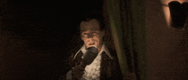 a man in a suit is holding a microphone in his hand