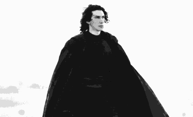 a black and white photo of a man in a cape .