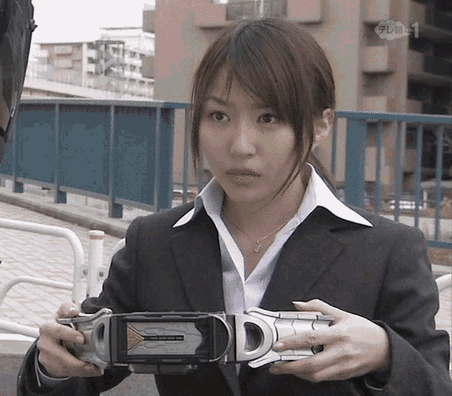 a woman in a suit holds a belt that says dd on it