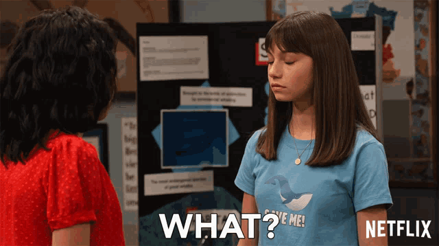 a girl wearing a t-shirt that says " what "