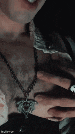 a man is wearing a necklace with a dragon pendant on it
