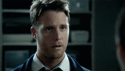 a man with a beard wearing a blue jacket and tie