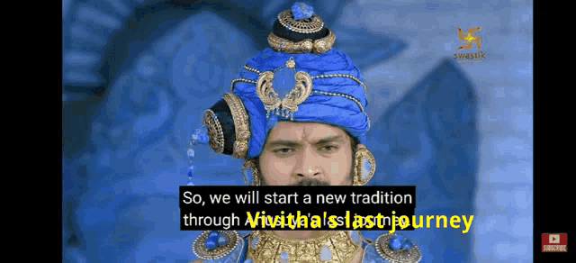 a man wearing a blue turban and gold jewelry says so we will start a new tradition through a journey