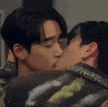 a couple of men are kissing each other on the cheek