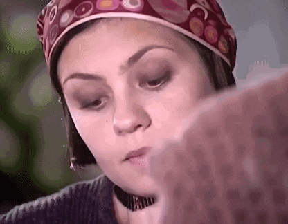 a close up of a woman wearing a head scarf and choker .
