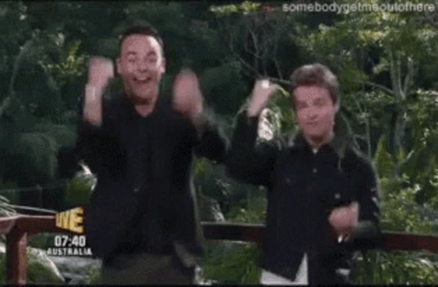two men are dancing in front of a sign that says australia on it