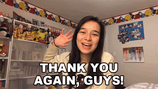 a girl says thank you again guys in front of a shelf full of stuffed animals