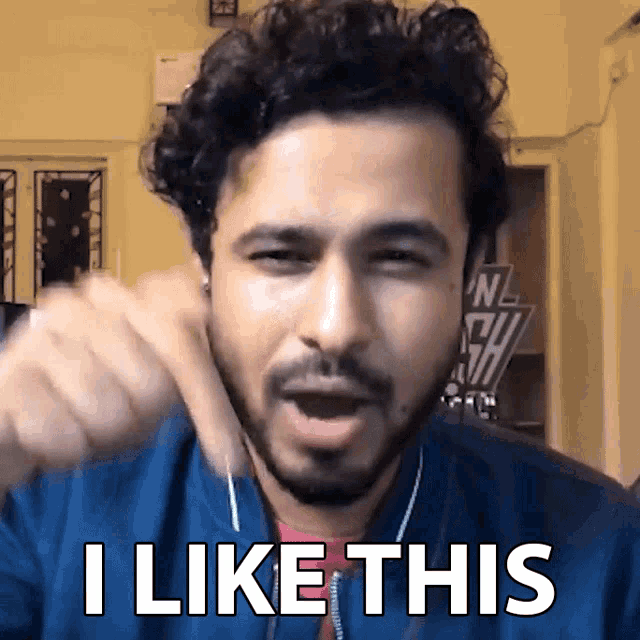 a man with a beard says " i like this " while pointing at the camera